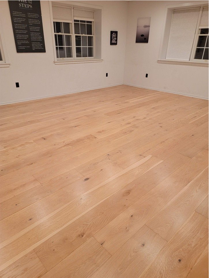 . Experience the beauty of freshly restored engineered hardwood floors. Our natural finish highlights the wood's natural grain, creating a clean and bright atmosphere. Keywords: Engineered hardwood restoration, natural finish hardwood, restored wood floors, clean hardwood finish, hardwood refinishing, engineered flooring, fresh hardwood look.